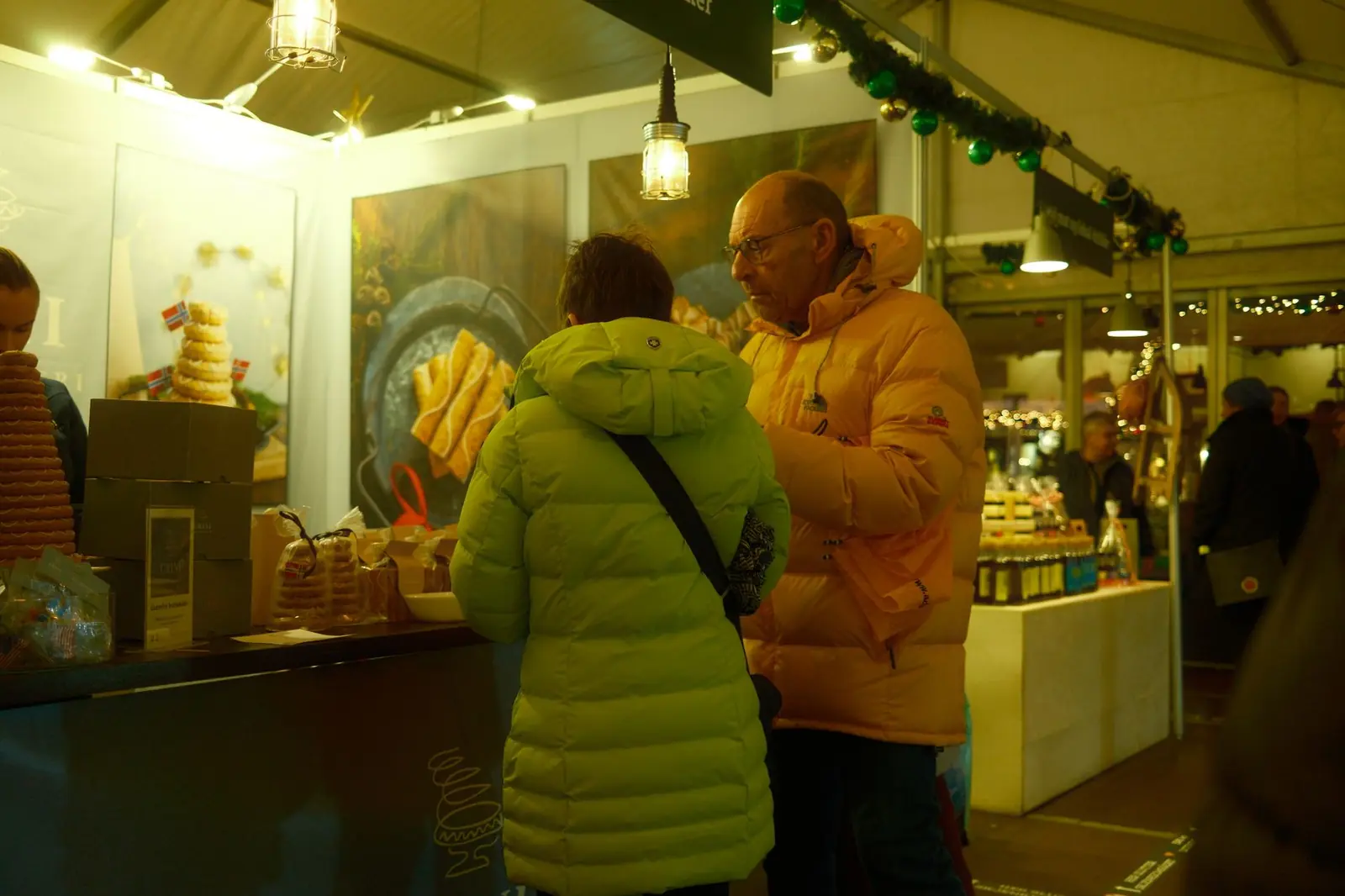 Bod på julemarked i Bergen med norske julekaker og varm belysning en vinterkveld