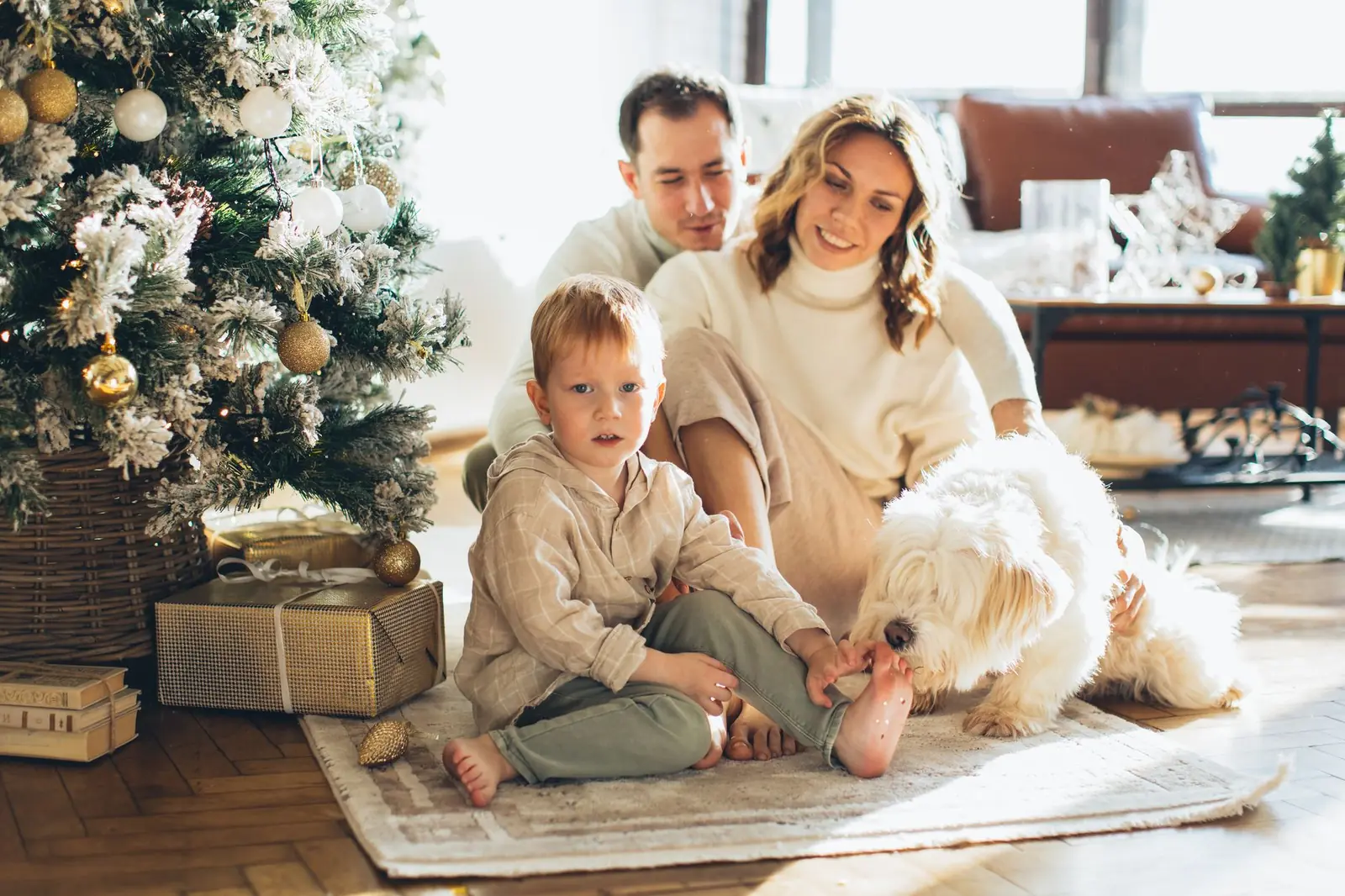 Familie med hund feirer julemorgen hjemme ved juletreet
