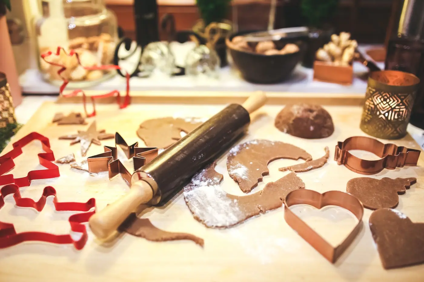 Pepperkakedeig, kjevle og utstikkere på et kjøkkenbord under julebaking
